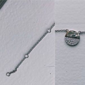 silver necklace. circle with stones on it.